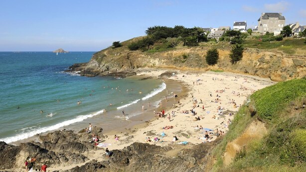 A coastal beach with rocky shores, a sandy beach area, and buildings in the background. - House Six - PLENEUF VAL ANDRE (PLENEUF VAL ANDRE)