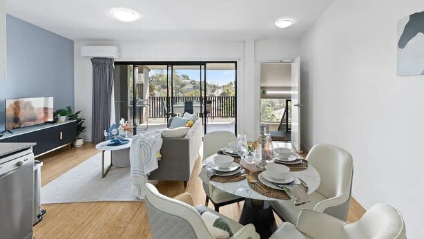 Un salon moderne comprenant un coin repas, un téléviseur et un balcon avec vue.