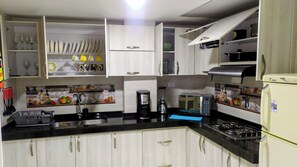 Microondas, cafetera y tetera, utensilios de cocina y condimentos 