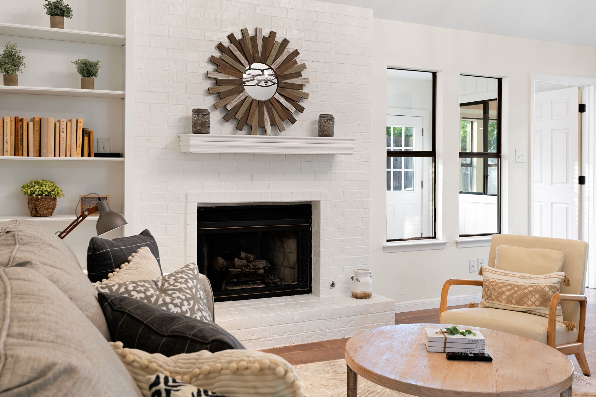 A living room with a fireplace, bookshelves, a sofa, and a coffee table.