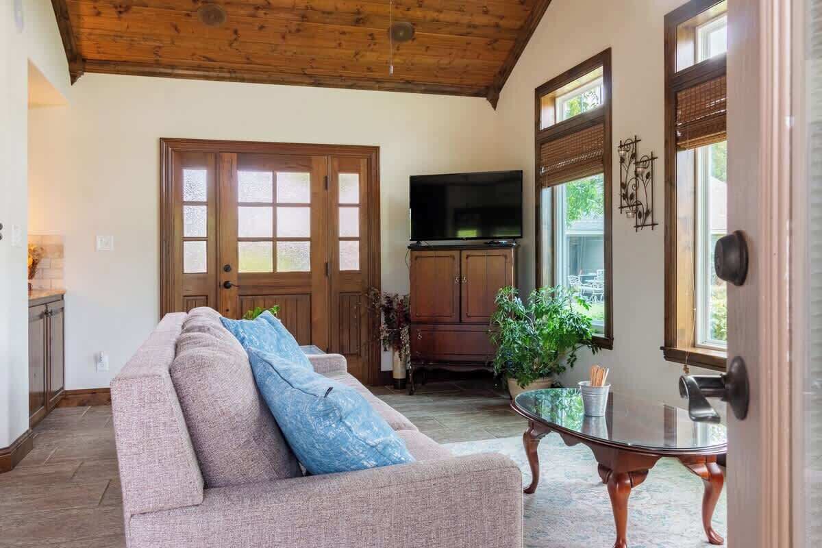 Ein Wohnzimmer mit einer Couch, einem Fernseher und einem Glastisch.