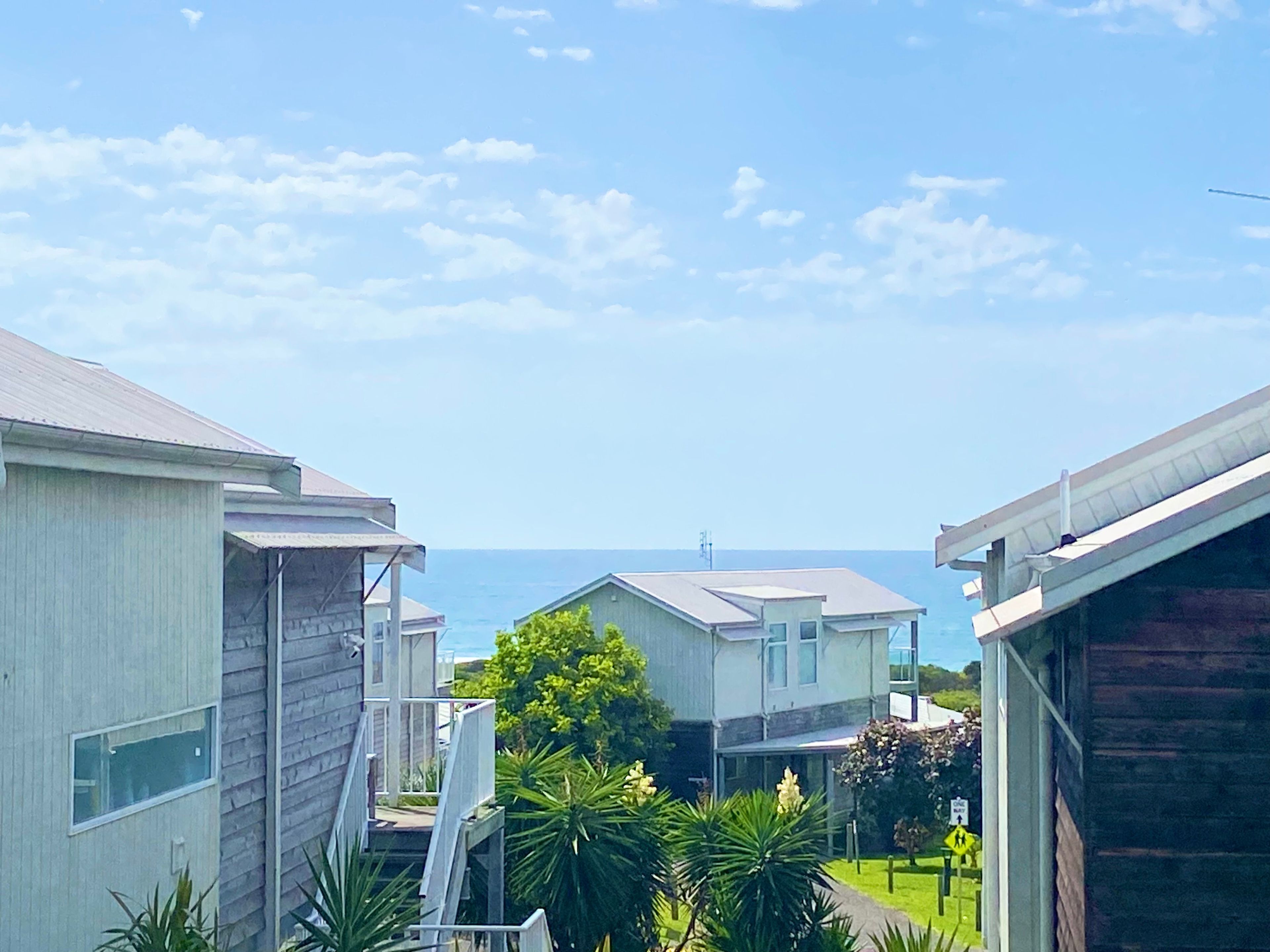A row of single-story houses with a clear view of the ocean.