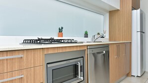 Een moderne keuken met een ingebouwde oven, vaatwasser en gasfornuis.