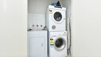 A compact laundry area with a front-loading washer and dryer stacked on top of each other.