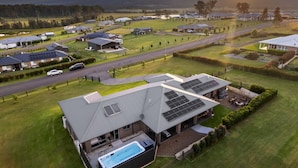 Un quartiere residenziale con case, una piscina e pannelli solari.