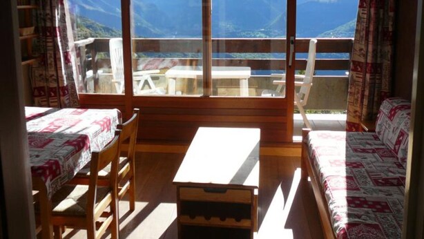 A room with a large window, wooden furniture, and a view of mountains. - Studio 'Pathabac' with Mountain View and Balcony (Auris)
