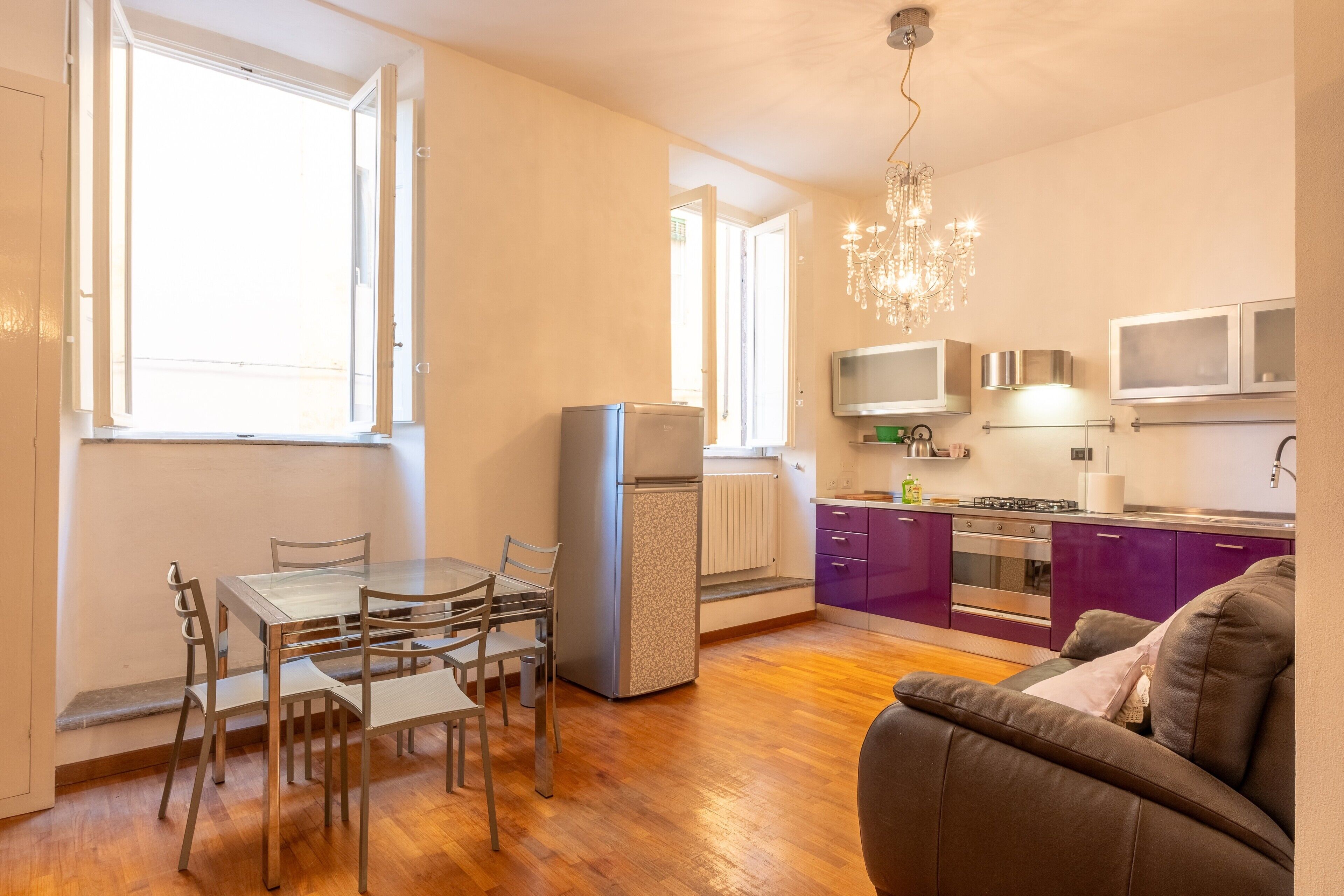 A compact living space with a dining area, kitchenette, and a sofa.