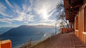 Una escalera de madera que conduce a un balcón con vistas a un paisaje montañoso.