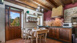 Une cuisine rustique avec des meubles en bois, un mur en pierre et un pare-feu en carreaux.