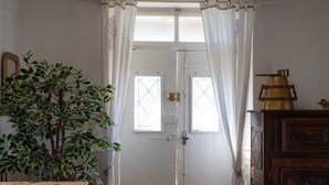 A white door with a window, a potted plant, and a wooden cabinet. - La Maison Du Soleil - L'aulhère, Jacuzzi, Terrace, Air Conditioning, Sleeps 6 (Ledeuix)
