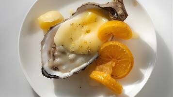 En tallerken med et østers, et skivede citron og et skivede appelsin.