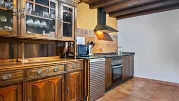 Une cuisine avec des meubles de rangement en bois, une cuisinière et un four à micro-ondes.