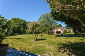 A grassy area with trees and a building in the background. - Holiday Home 'Du Parc' with Lake View, Wi-Fi and Air Conditioning (Genouillé)