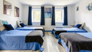 A hotel room with four beds arranged in a row, a window with curtains, and artwork on the walls. - Holiday Home 'Du Parc' with Shared Pool, Lake View & Wi-Fi (Genouillé)