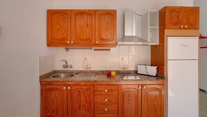A kitchen with wooden cabinets, a stainless steel sink, a white refrigerator, and a toaster. - Vacation Apartment 'Los Angeles 1' with Sea View, Shared Terrace and Wi-Fi (Playa de Mogán)