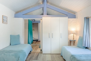 A bedroom with two beds, a wardrobe, a lamp, and a view of a hallway. - Holiday Home 'L'Océan' with Lake View, Wi-Fi and Air Conditioning (Genouillé)