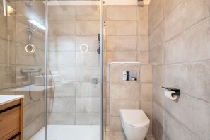 A modern bathroom with a glass-enclosed shower, a toilet, and a wooden vanity. - Finca 'Cas Forner' with Mountain Views, Private Pool and Wi-Fi (Illes Balears)
