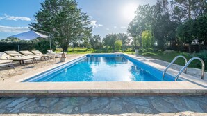A swimming pool with lounge chairs and a stone deck. - Finca 'Cas Forner' with Mountain Views, Private Pool and Wi-Fi (Illes Balears)