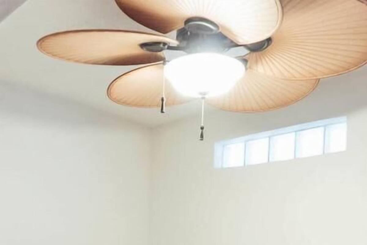 A bedroom with a bed, a ceiling fan, and a window.