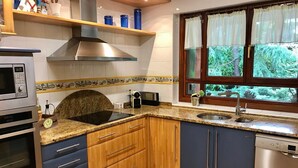 Een keuken met een ingebouwde kookplaat, oven, magnetron en vaatwasser.