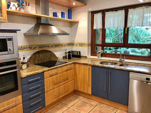 A kitchen with a built-in stove, oven, microwave, and dishwasher. - Holiday Home in a Perfect Location with Garden and BBQ (Murgia)