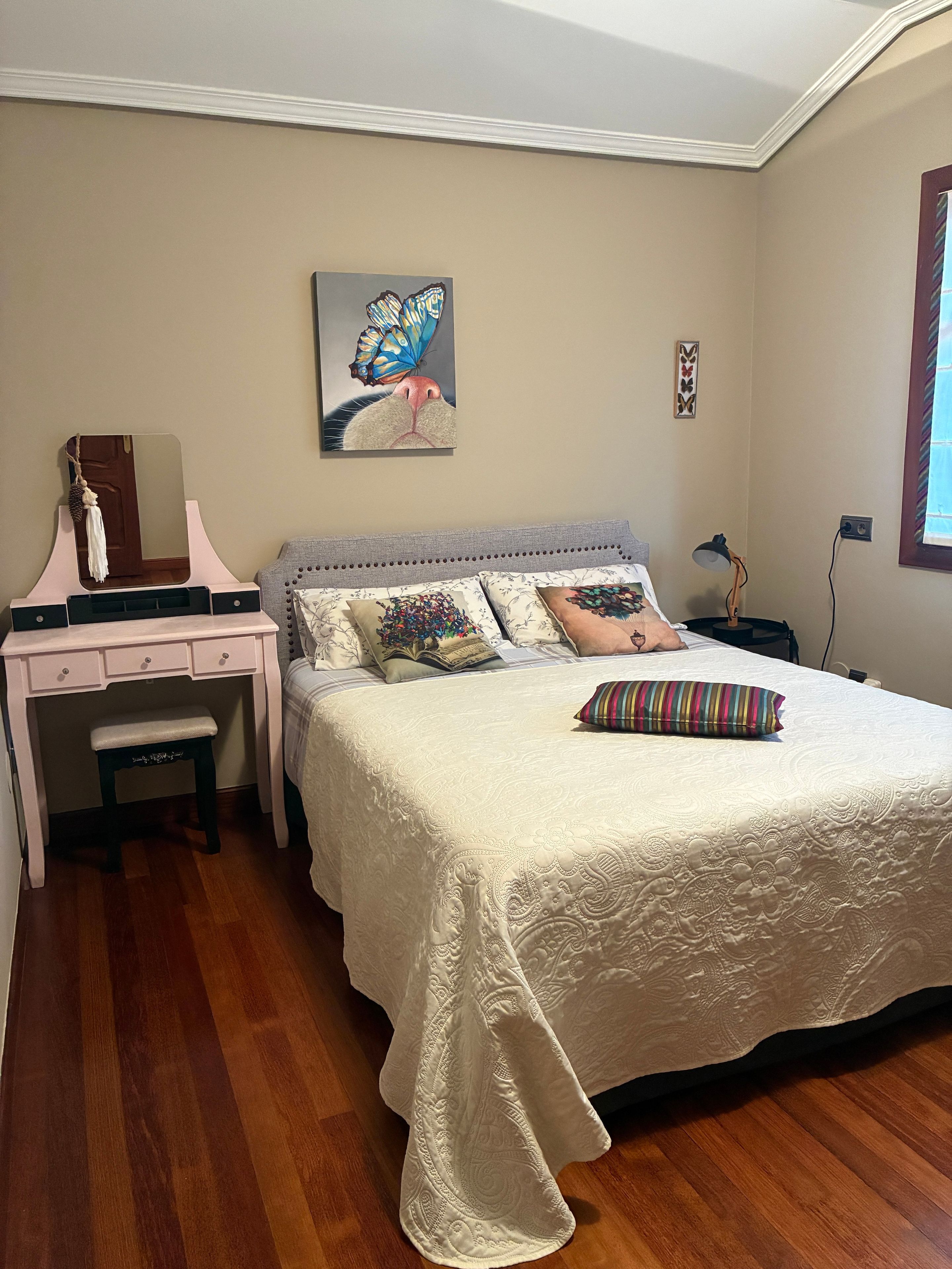 Un dormitorio con una cama, un escritorio y una silla.
