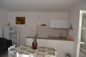 Réfrigérateur, un four, surface de cuisson, vaisselle et ustensiles