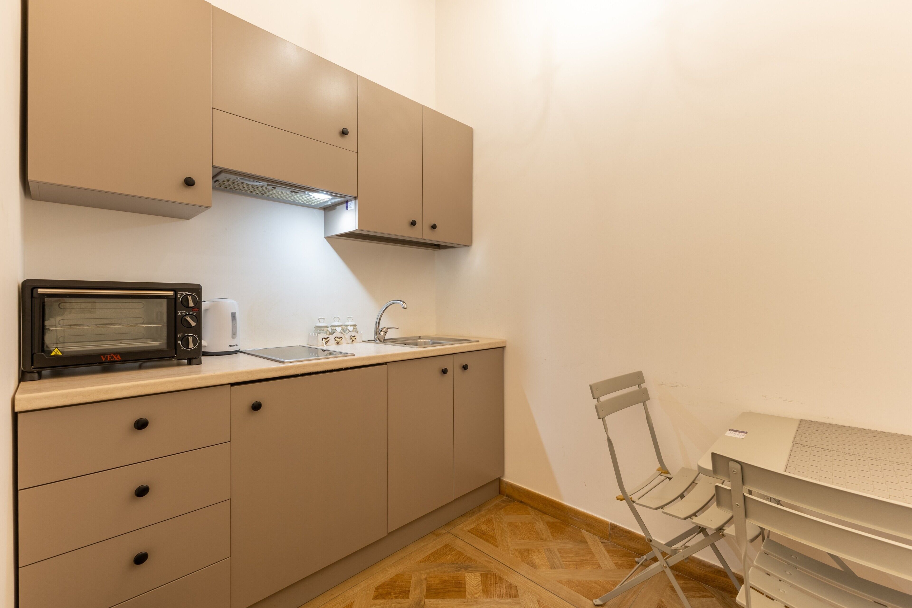 Una kitchenette equipada con microondas, tostadora, pileta y alacenas.