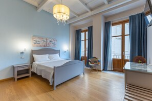 A bedroom with a bed, a nightstand, a chair, a desk, a chandelier, and a window with curtains. - Room 'Al Duomo - Junior Suite' with Shared Terrace, Wi-Fi and Air Conditioning (Licata)