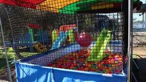 A playground enclosure with a ball pit and various play structures.