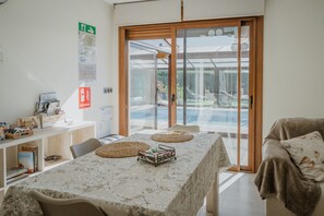 A room with a large table, chairs, a sofa, and a sliding glass door leading to a balcony. - Adults Only Country House 'La Costana De Barbadillo' with Private Garden, Wi-Fi and Air Conditioning (Barbadillo Del Mercado)