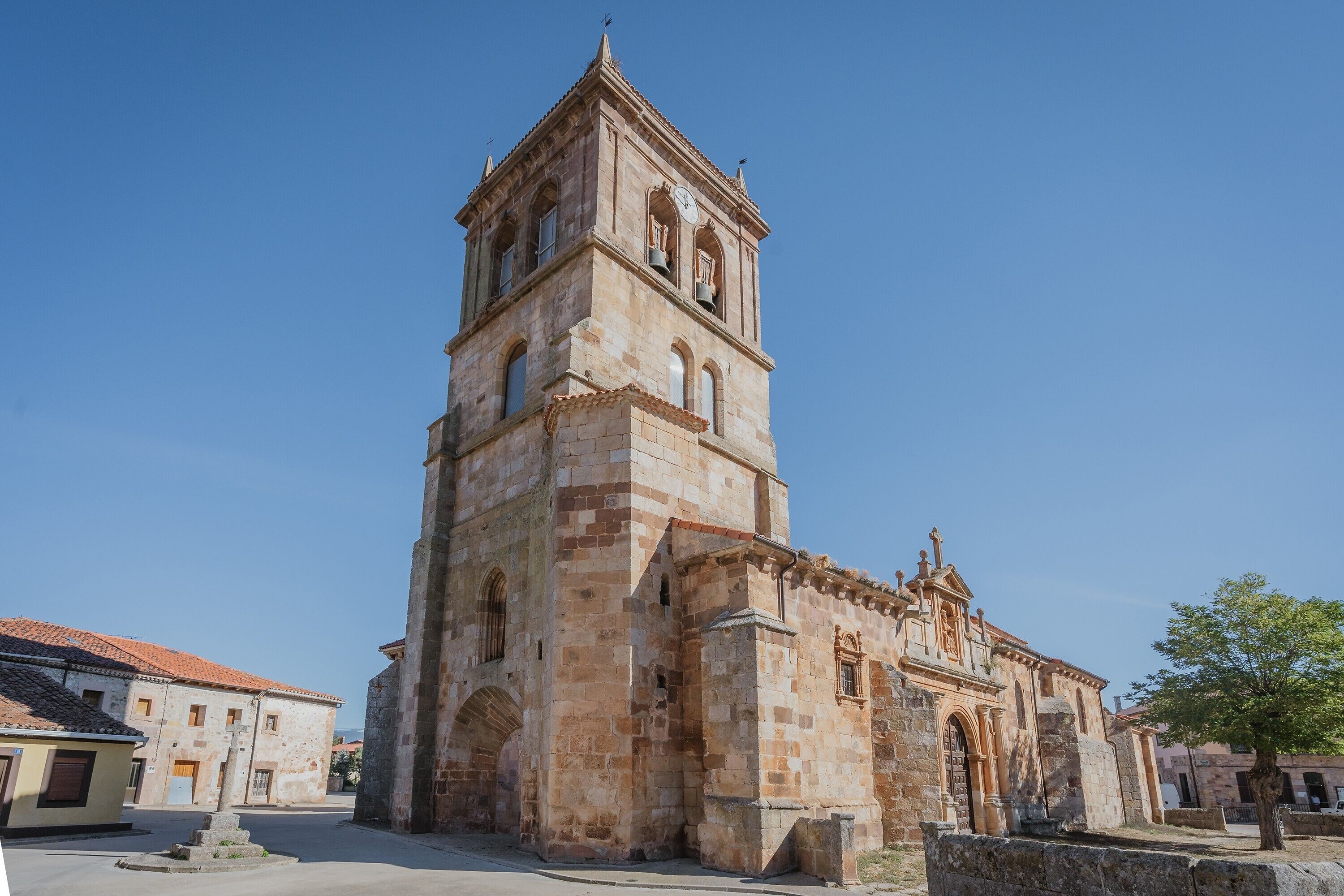 A historic stone church with a bell tower, arched windows, and a central doorway.