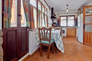 A kitchen with a dining table, chairs, a stove, and a washing machine.