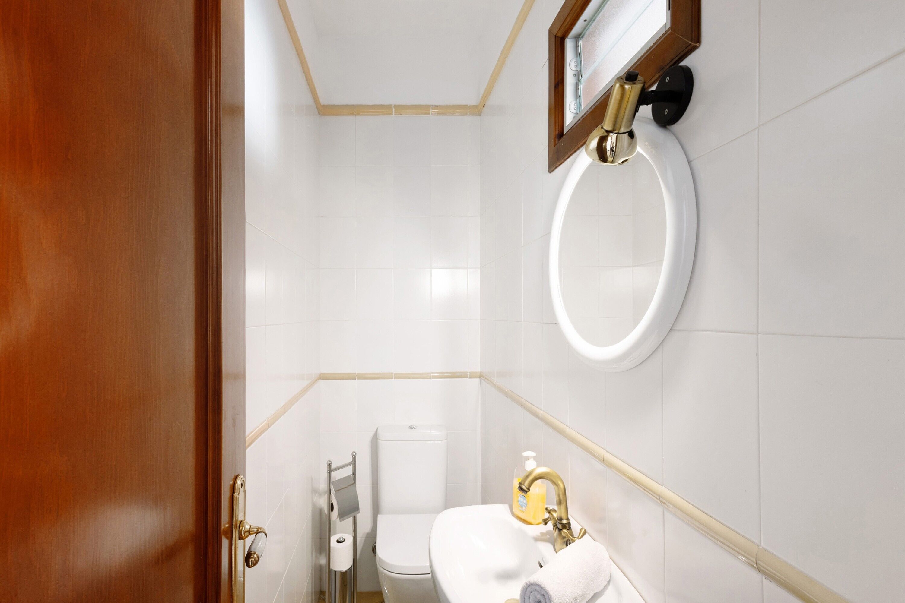 A bathroom with a toilet, sink, and towel rack.