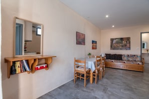 Un comedor con mesa, sillas, una estantería y un sofá.