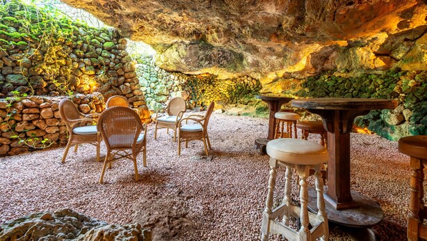 An interior with stone walls, wicker furniture, and a rustic ambiance. - Country House 'Ses Estaques' with Mountain View, Shared Pool and Wi-Fi (Illes Balears)