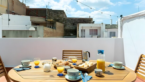 A breakfast table set on a balcony with a city view, including buildings and a clear sky. - Country House 'Casa Rural Angelita' with Mountain View, Wi-Fi and Air Conditioning (Rossell)