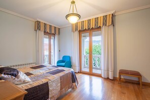 A bedroom with a bed, a bench, a chair, and a balcony with a view. - 'Apartment 12' with Shared Pool, Private Terrace and Wi-Fi (Cangas)