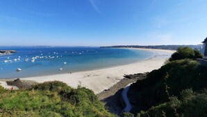 A coastal beach with boats, a clear sky, and a rocky shoreline. - Holiday Home 'Mézon Ermine' with Terrace, Private Garden and Wi-Fi (Saint-Cast-le-Guildo)