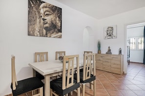 Ein Essbereich mit Tisch, Stühlen und einem Schrank.