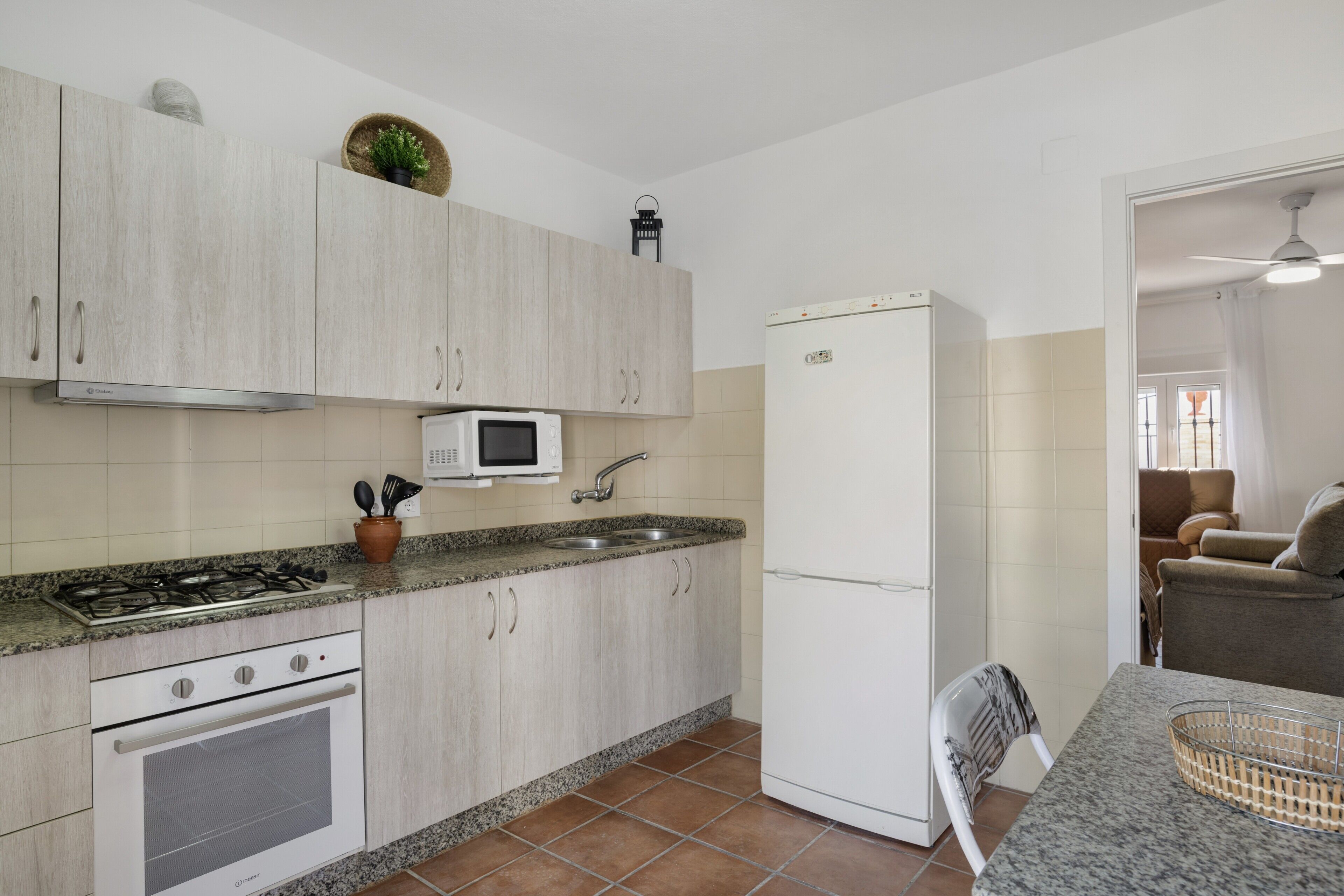 Una cocina equipada con estufa, horno, microondas, lavabo y refrigerador.