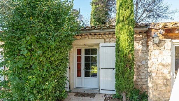 A stone building with a tiled entrance, a door, and a small tree. - Provençal Gîte "La Rivière" – 4 Bedrooms, Private Terrace, Pool & Garden by the Sorgue (Velleron)