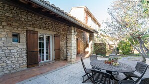 A stone building with a patio, outdoor seating, and potted plants. - Provençal House “Le Patio” – 2 Bedrooms, Private Terrace, Pool & Garden in Velleron (Velleron)