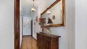 Un pasillo con un armario de madera, un espejo grande y un suelo con diseño.