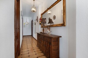 Un corridoio con un armadietto in legno, un grande specchio e un pavimento decorato.