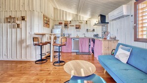 Eine gemütliche Küche mit Holzwänden, einem blauen Sofa und einem Essbereich mit einem runden Tisch.