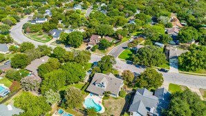 An aerial view of a residential area with houses, roads, and a swimming pool. - 70s House Fun 6 Bedroom Pool Game Room (Round Rock)
