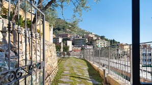 A stone pathway leading to a terrace with a view of a hillside town. - Apartment 'Agriturismo Le Pale - Giuli 2' with Sea View, Wi-Fi and Air Conditioning (Bogliasco)