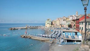 A coastal town with buildings, a pier, and beach umbrellas. - Apartment 'Agriturismo Le Pale - Giuli 2' with Sea View, Wi-Fi and Air Conditioning (Bogliasco)