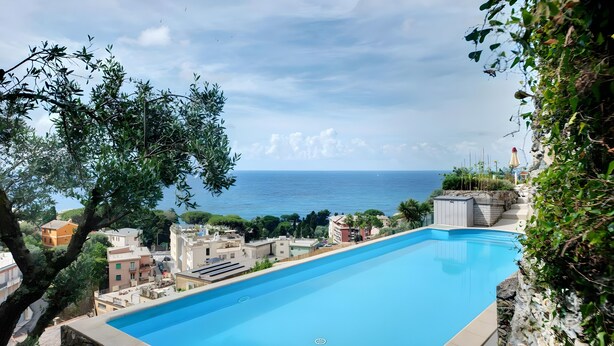 A swimming pool with a view of the sea and buildings. - Apartment 'Agriturismo Le Pale - Giuli 2' with Sea View, Wi-Fi and Air Conditioning (Bogliasco)
